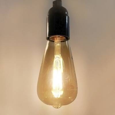 Vintage LED lampa s černým podstavcem, zavěšená na hladkém pozadí - ideální pro retro a energeticky úsporná řešení osvětlení.