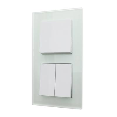 Moderní bílý spínací panel LED se třemi vypínači umístěnými na stylovém skleněném panelu.