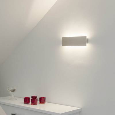 Minimalistický koutek s nástěnnou lampou LED, červenými svíčkami na bílé polici a skleněnou miskou; ideální pro moderní osvětlení a interiérový design.