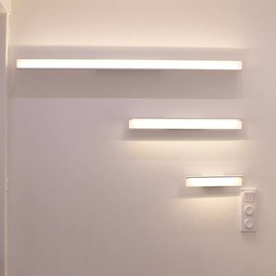 Minimalistická vodorovná nástěnná svítidla různých délek pro hladkou stěnu s panelem pro vypínač světla pod nimi. Moderní funkce LED osvětlení obchodu.
