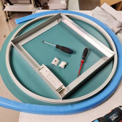 Dva šroubováky a elektrické komponenty s modrozeleným pěnovým povrchem, akcentní nářadí pro instalaci osvětlení LED.