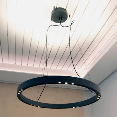 Elegantní kulatý lustr LED s několika světly zavěšenými na bílém stropě. Viditelná kabeláž dotváří industriální atmosféru. Skvěle se hodí do moderních interiérů.