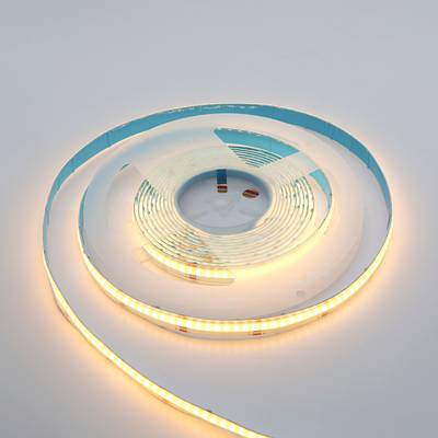 Teple zářící LED pásek stočený na bílém povrchu - stylové, energeticky úsporné osvětlení pro domácnosti a firmy.