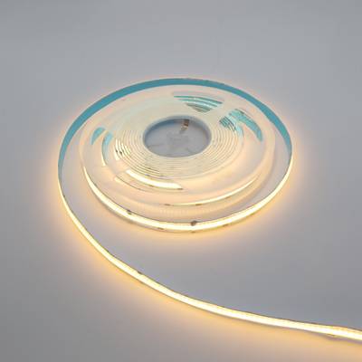 Teplý bílý LED pásek stočený na rovný povrch, energeticky úsporné osvětlení pro domácí dekoraci a atmosféru.