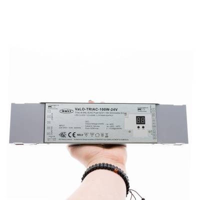 Detail ruky držící stmívač LED VaLO TRIAC-100W-24V s digitálním displejem, který zvyšuje energetickou účinnost osvětlení LED.
