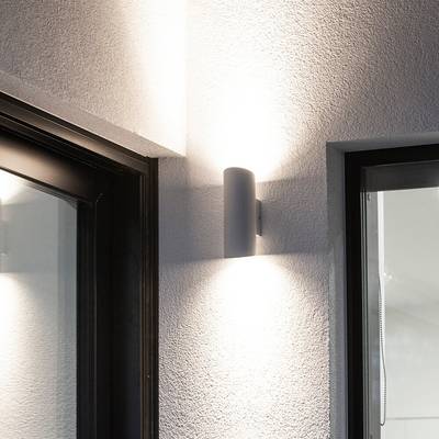 Nástěnné svítidlo LED vytváří na strukturovaných stěnách mezi okny útulnou záři, která zvyšuje náladové osvětlení a styl.
