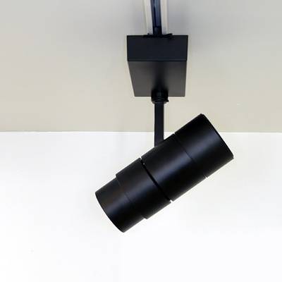 Detailní záběr černého válcového světelného pásu na bílém stropě pro moderní řešení osvětlení LED.