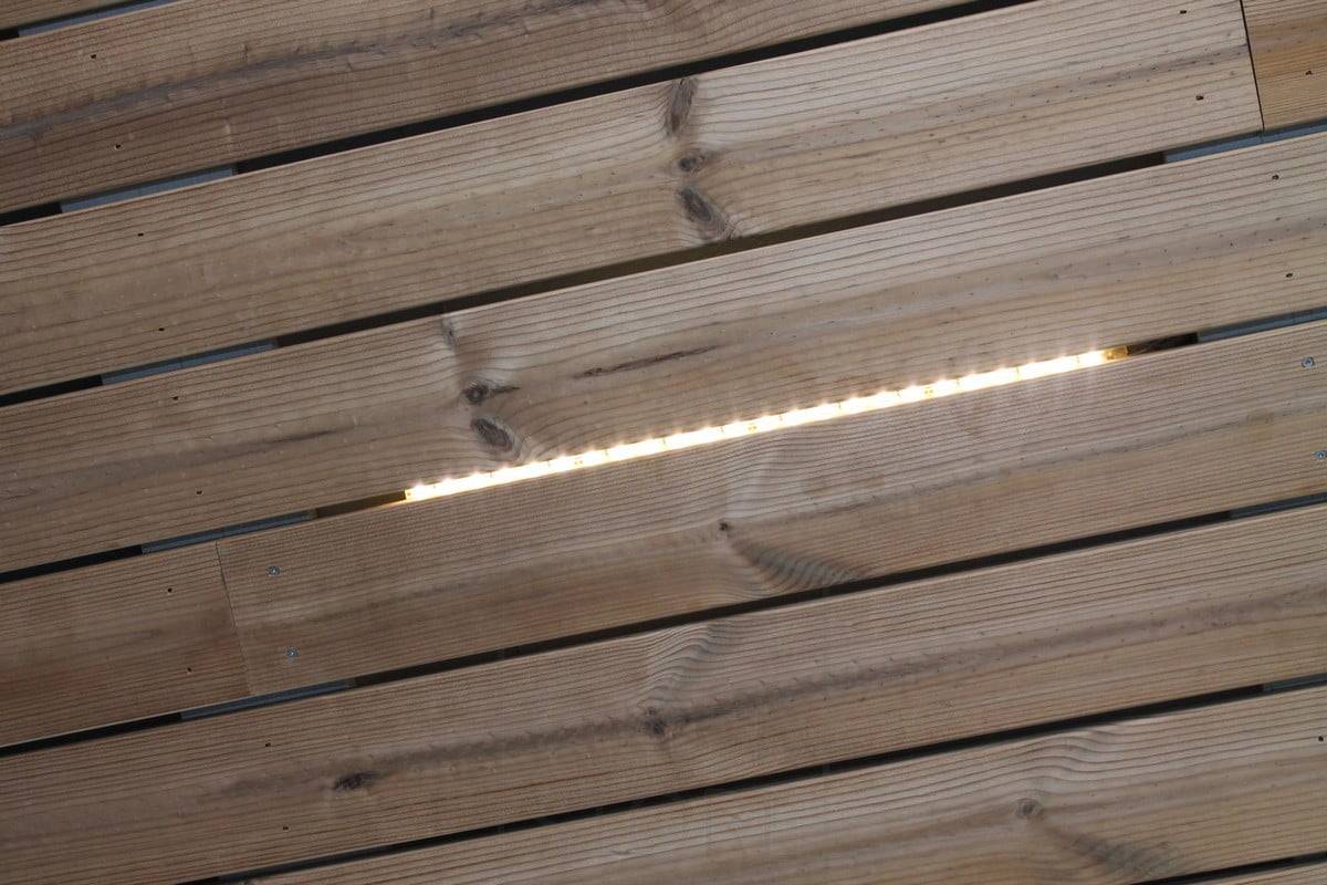 Veletrh bydlení 2014: kousky pásu Led nad štěrbinou v desce, detailní záběr. Ledstore.fi