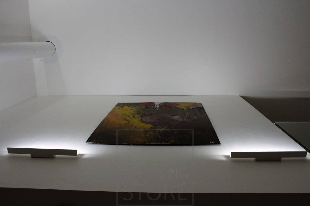Nástěnné svítidlo s čepelí osvětlující zdola nahoru a zvýrazňující umělecká díla nepřímým světlem. Ledstore.fi
