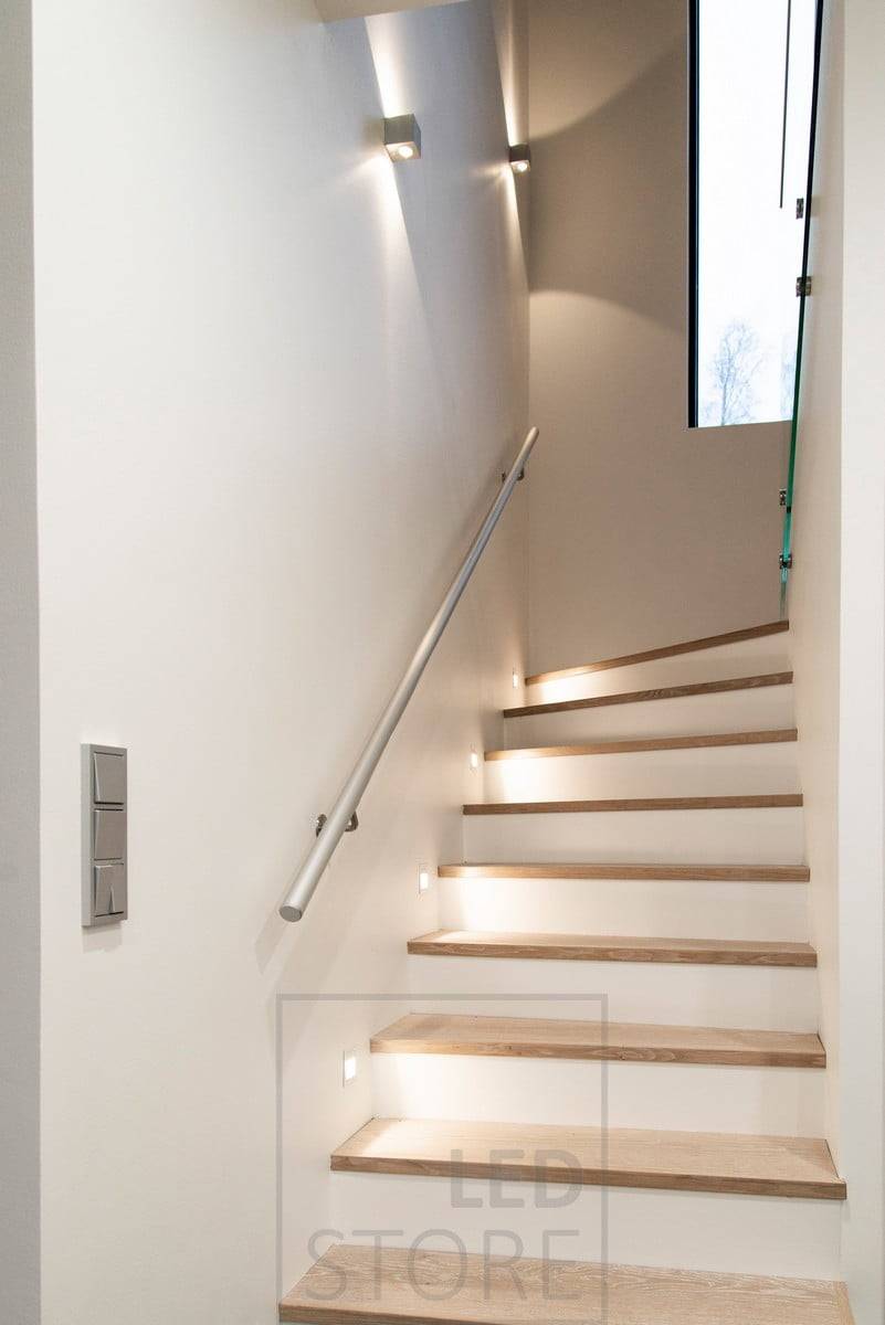 Nástěnná svítidla CUBIC led na schodišti, která osvětlují atmosférickým světlem ve dvou směrech. Nástěnná led svítidla IN-WALL namířená na schody. Ledstore.fi