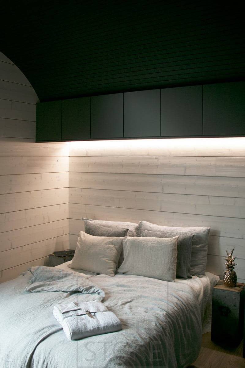 LED pásky připevněné k podstavci nástěnných skříněk poskytují v ložnici náladové osvětlení s nepřímým světlem. Ledstore.fi