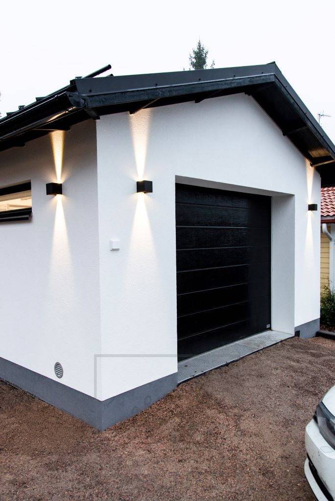 Černá nástěnná svítidla FUNK LED osvětlující fasádu garáže. Světlo směrem nahoru končí u okapu. Ledstore.fi