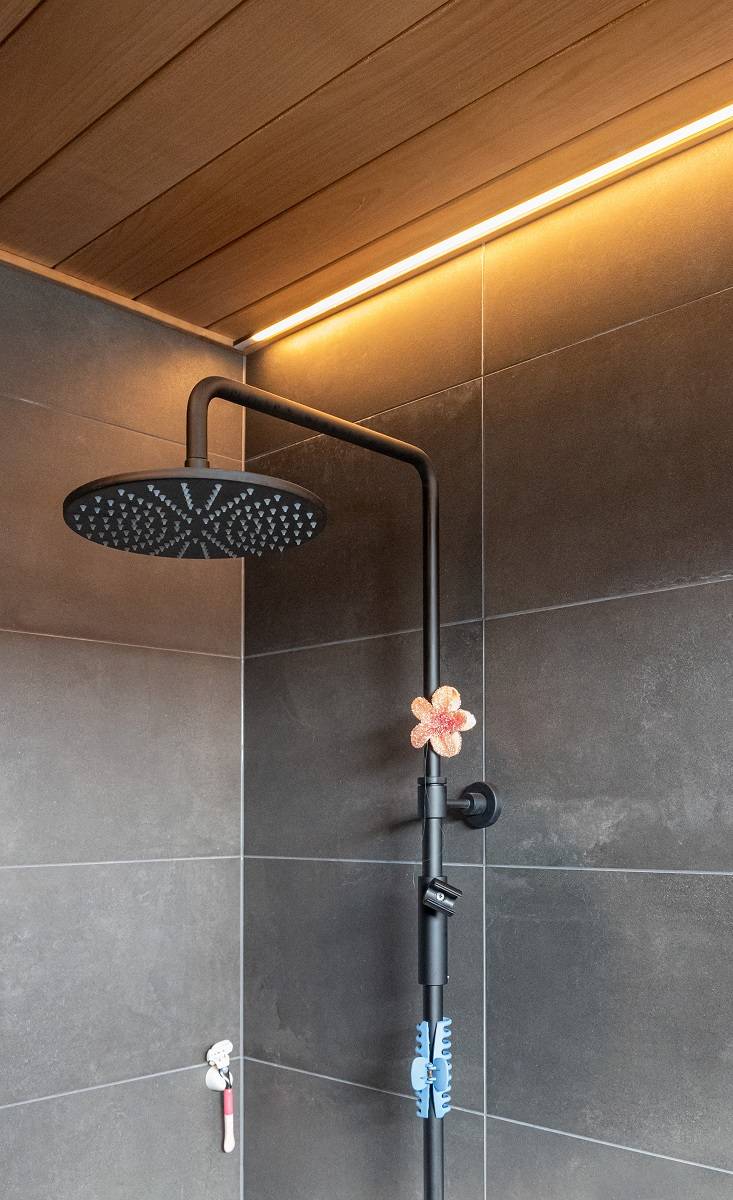 Koupelna s LED páskem zapuštěným do stropu vedle stěny.