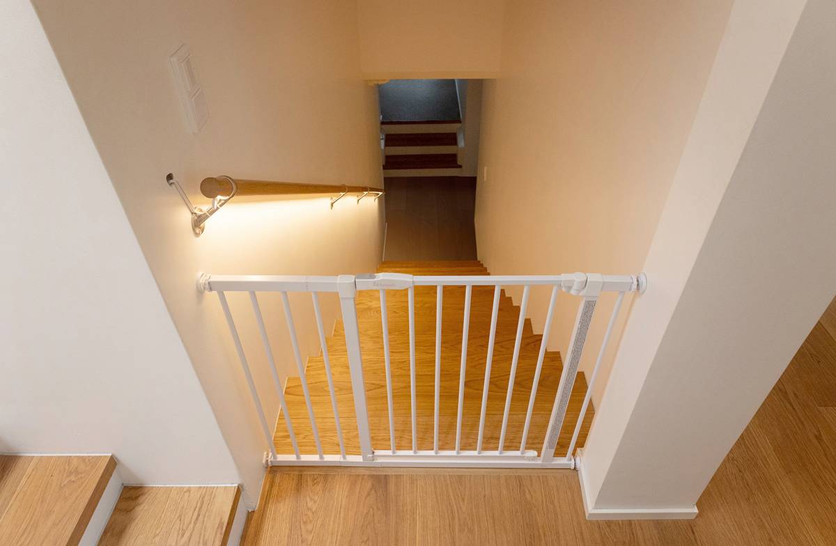 LED páska instalovaná pod zábradlím schodiště osvětluje schody směrem dolů.