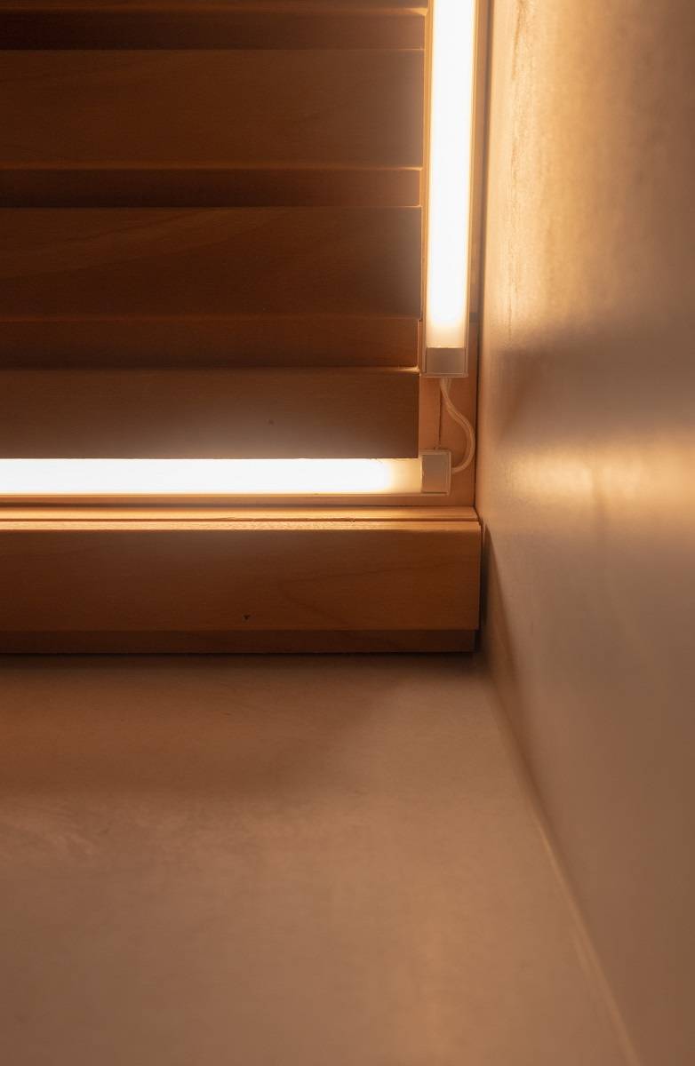 Detailní záběr instalace LED pásku na stropě koupelny.