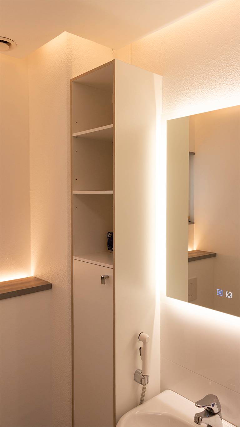 Nepřímé světlo v koupelně. Světelné zrcadlo v kombinaci s nepřímým světlem ze stropu a LED páskem směřujícím vzhůru za záchodovou skříňkou. Ledstore.fi