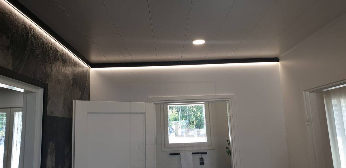 Dekorativní černý nástěnný profil s led páskem poskytujícím nepřímé světlo. Ledstore.fi