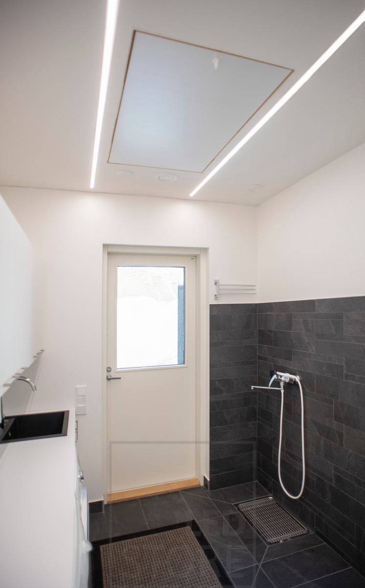 Led pásky v zapuštěných profilech ve stropě vytvářející celkové osvětlení prostoru. Ledstore.fi