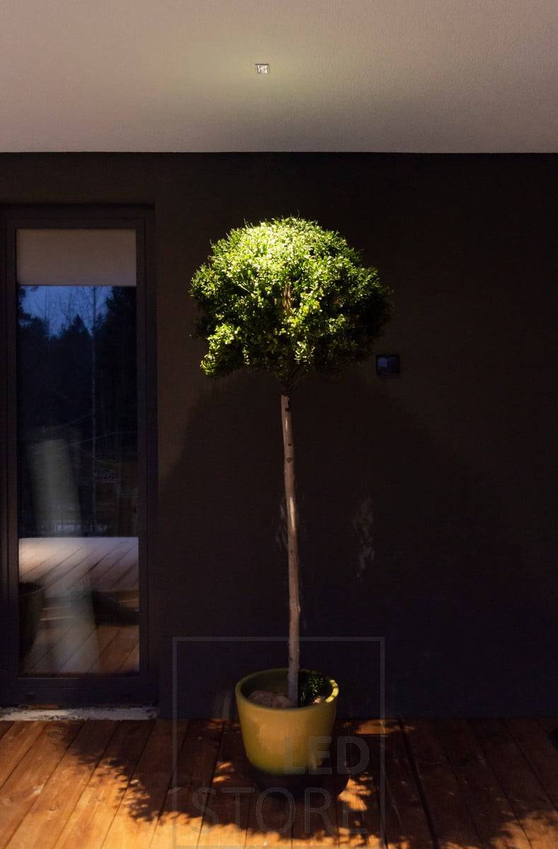 Venkovní reflektor LINJA 2 na střeše terasy. Zdůrazňuje a osvětluje venkovní rostliny a vytváří atmosférické světlo na terase. Ledstore.fi