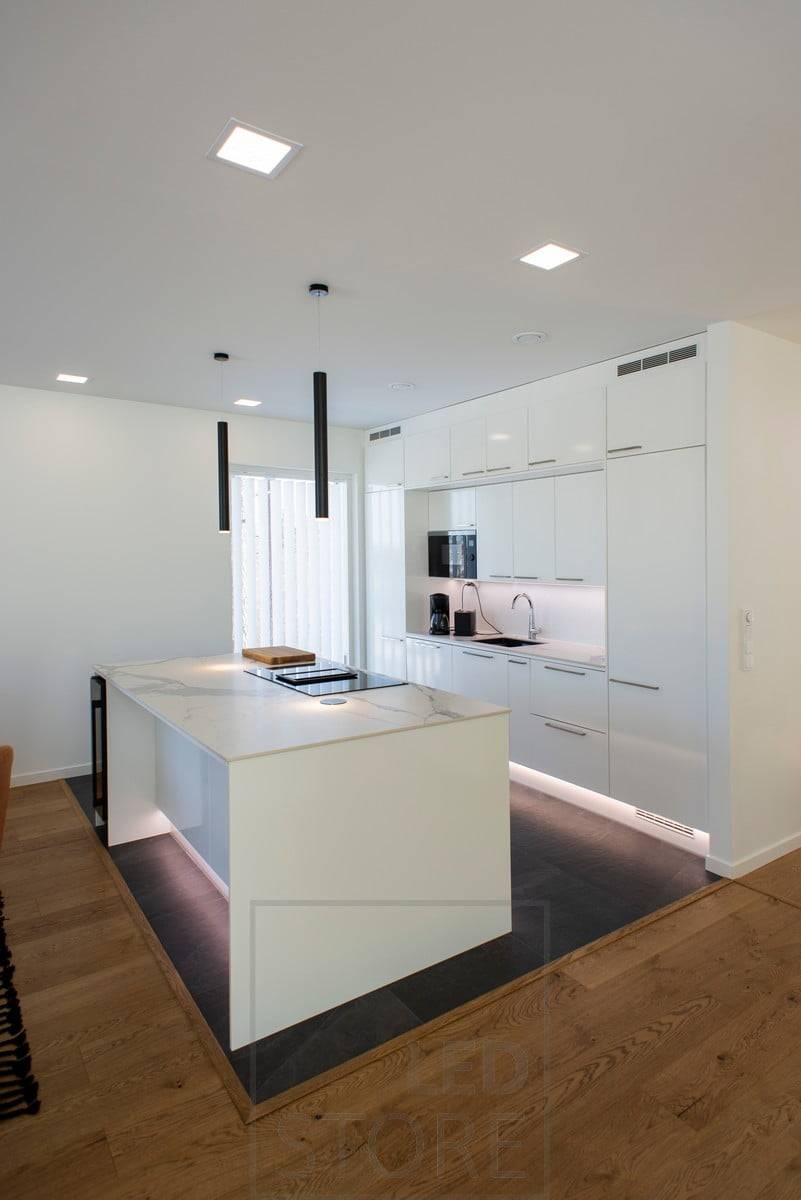 Všestranné a kvalitní osvětlení v kuchyni. Led panely jako celkové osvětlení, komínová závěsná světla nad ostrůvkem a led pásky na soklech a nad pracovní deskou. Ledstore.fi