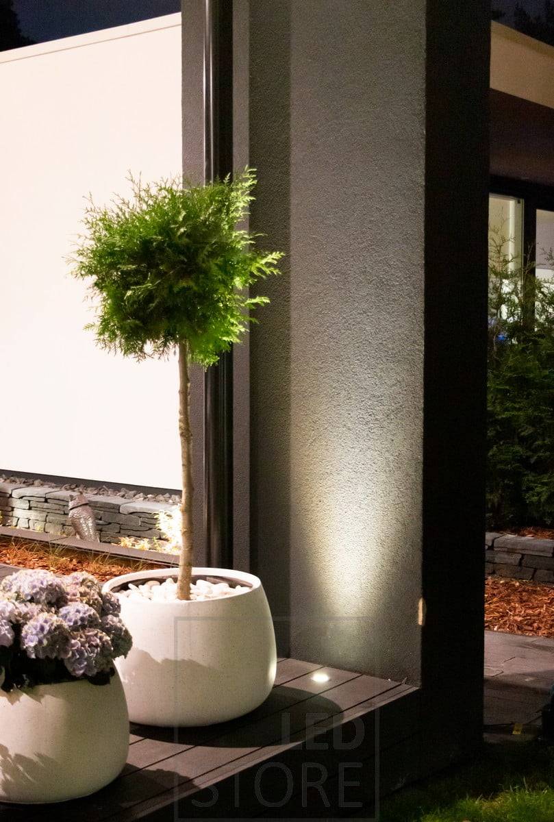 Reflektor svítící vzhůru a zabudovaný do terasy využívá stěnu jako odraznou plochu. Světlo zároveň krásně zvýrazňuje rostlinu před ním. Ledstore.fi