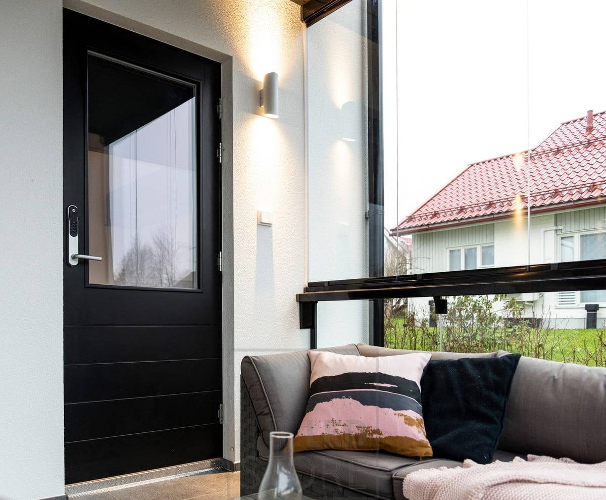 Bílé nástěnné svítidlo Viisto vedle vchodu. Svítidlo osvětluje stěnu ve dvou směrech teplým a měkkým 3000K světlem. Ledstore.fi
