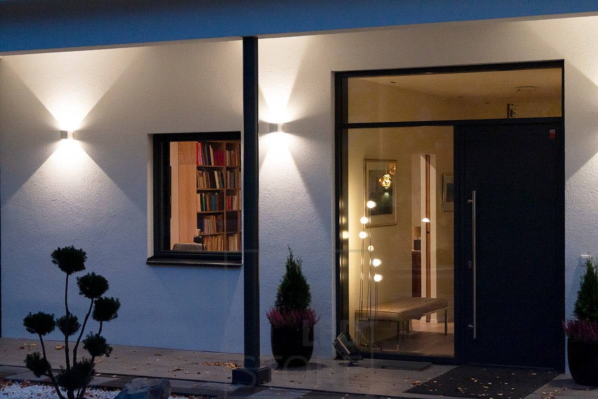 Bílá obousměrná nástěnná svítidla FUNK osvětlující fasádu a vchod. Ledstore.fi