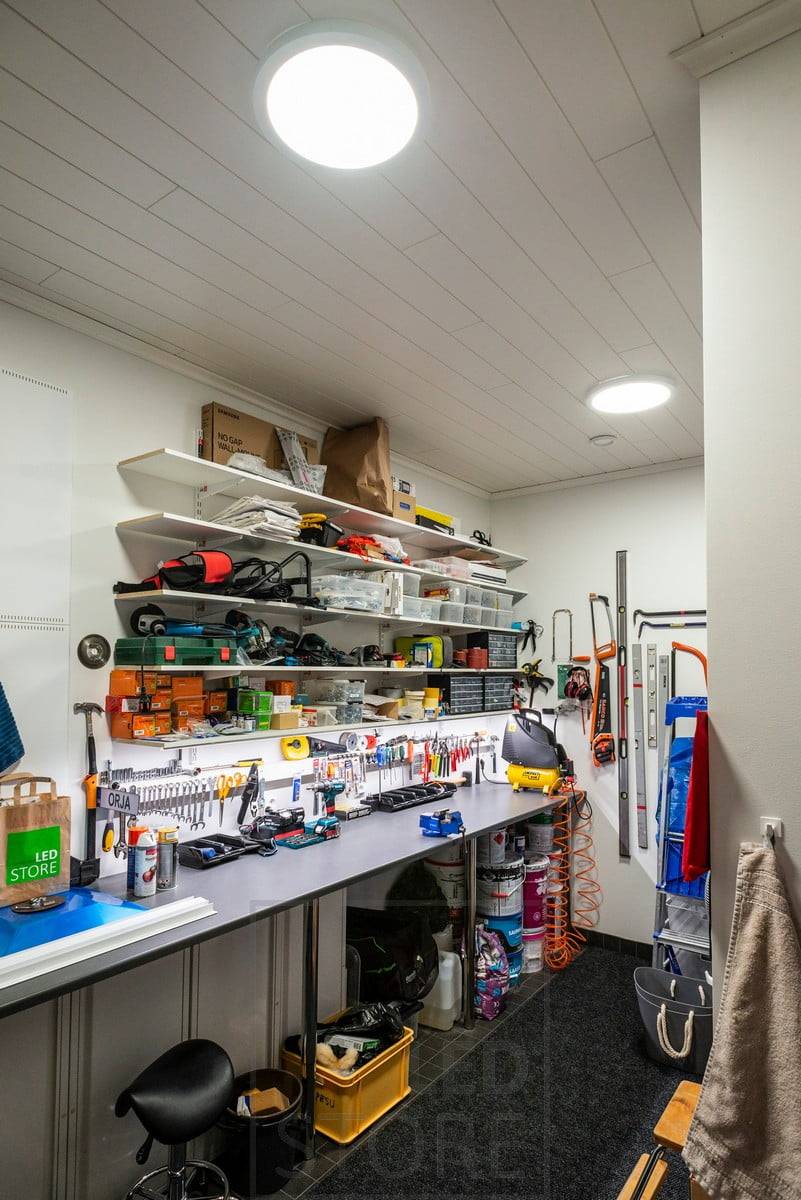 Pracovní místo ve skladu s velkými stropními závěsnými světly na stropě. Ledstore.fi
