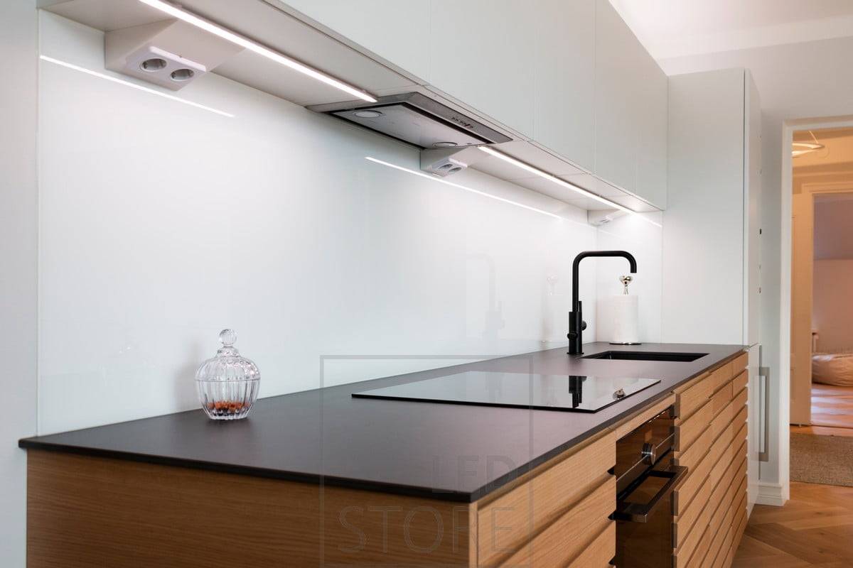 LED profil namontovaný uprostřed základny horních skříněk osvětlující pracovní desku. Ledstore.fi