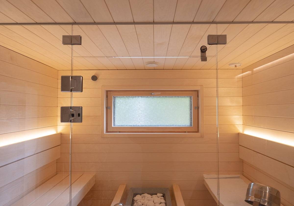 Sauna s led světelným páskem na opěradle osvětlujícím směrem nahoru. Dva LED pásky postačují k osvětlení sauny, když se světlo nechá otevřené.