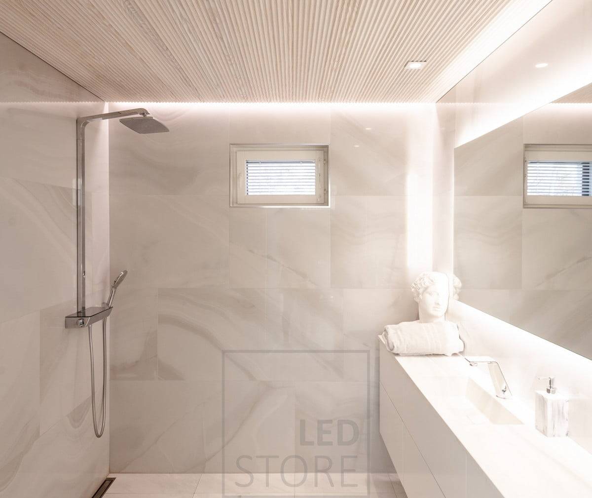 Koupelna má všestranné a atmosférické osvětlení. HALO 1200 jako světelné zrcadlo a CHEAP KANTTI led spoty na úrovni osvětlující obličej shora. Led pásek instalovaný v drážce mezi stropem a stěnou pro osvětlení prostoru nepřímým náladovým osvětlením přes stěnu. Ledstore.fi  