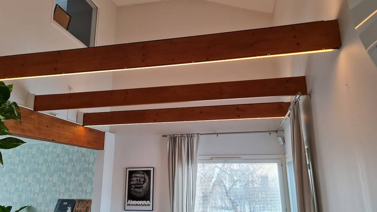 Nepřímé osvětlení v obývacím pokoji je úspěšné díky trámům.