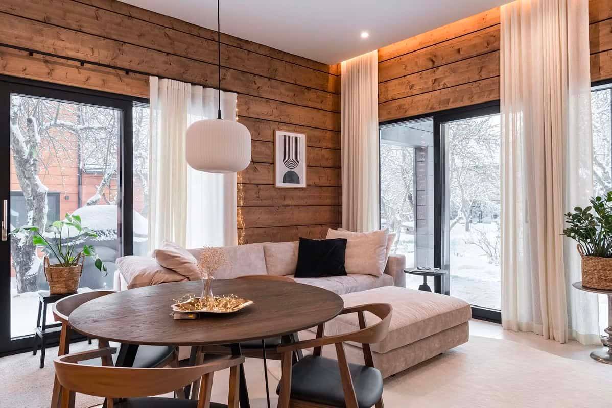 Moderní a teplý obývací pokoj s LED svítidly LedStore.fi, která zvýrazňují dřevěné povrchy a architekturu prostoru.