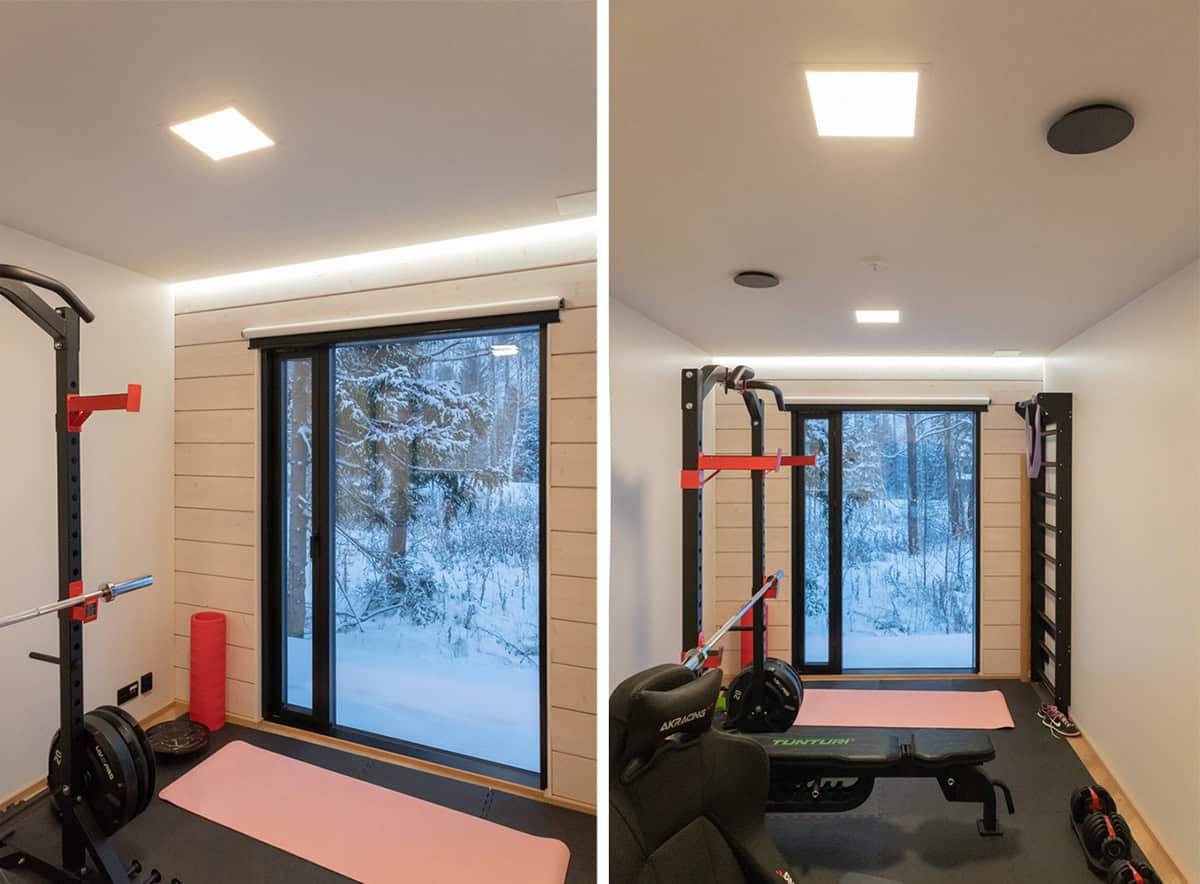 Malá tělocvična s velkým oknem ven, dvěma malými panelovými světly na stropě a led páskem nad oknem.