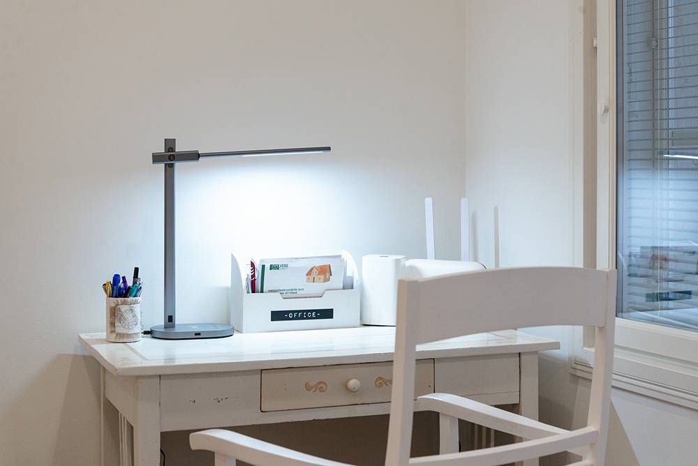 Stolní lampa Crane od společnosti LedStore osvětluje světlé pracovní místo.