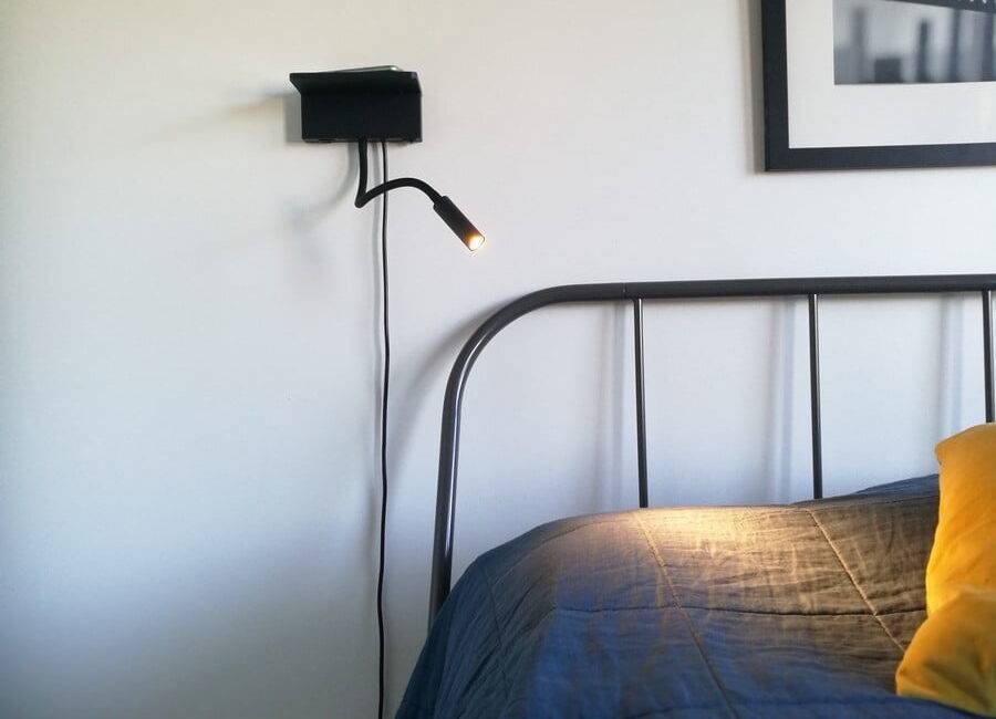 Noční lampička a lampička na čtení v čele postele. Lampa má bezdrátové nabíjení i slot USB pro nabíjení telefonu. Ledstore.fi