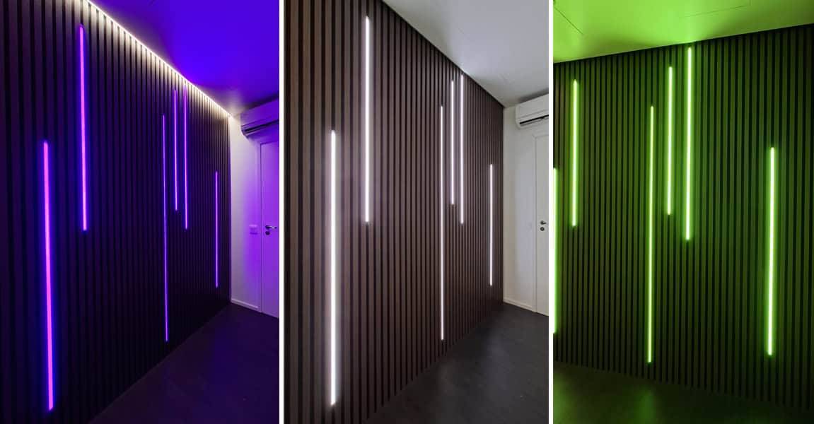 Elegantně obložená tmavá stěna s LED diodami LedStore.fi zářícími modře, bíle a zeleně.